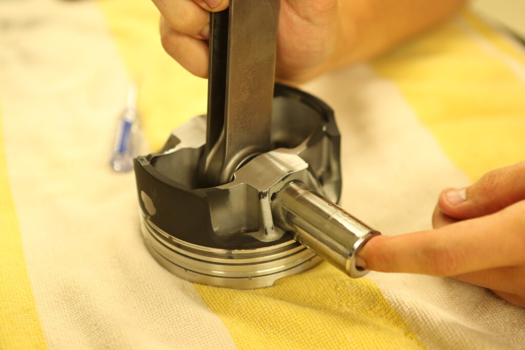 wrist pin being installed on a piston assembly
